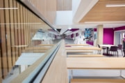 Wester Hailes HS breakout space: A view of the central atrium in the new Wester Hailes High School, featuring mixed seating and a pink-based mural.