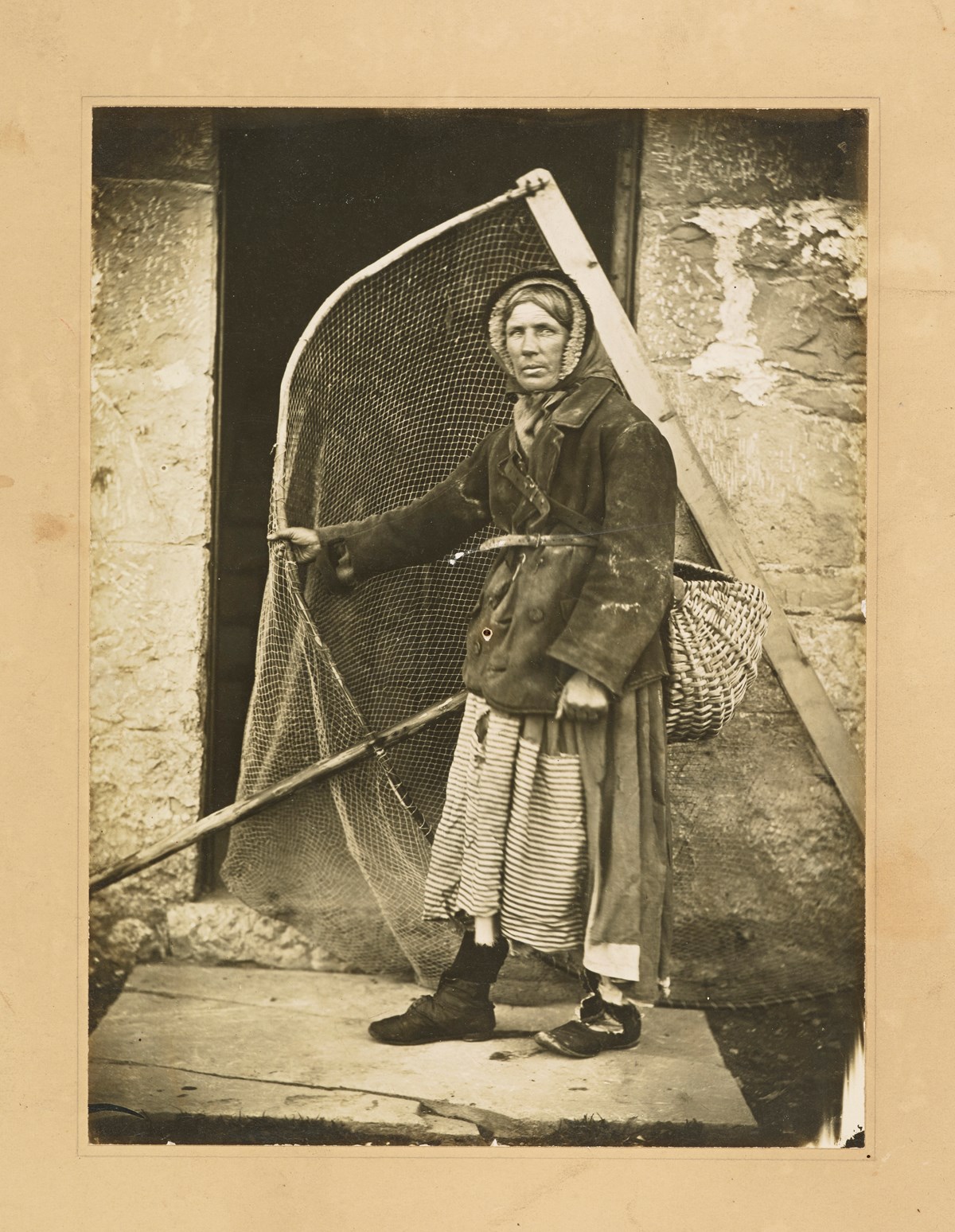 Unknown photographer
Fish wife with net , 1890s 
Albumen print 
Collection: National Library of Scotland, MacKinnon Collection, acquired jointly with the National Galleries of Scotland with assistance from the National Lottery Heritage Fund, the Scottish Government and Art Fund