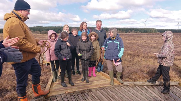 The boardwalk is officially opened with a 'ribbon' cutting ceremony: The 'ribbon', or handmade moss rope, is cut by pupils from Blackridge PS, officially opening the new boardwalk. 
Pictured L-R: Rob Forest CEO GreenPower, Amee Hood Reserve Manager, Heather Reid NatureScot Board member and school children.
