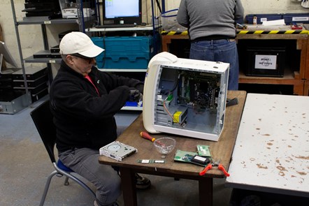 A member of the ReBOOT team dismantles a computer for spares or repairs.