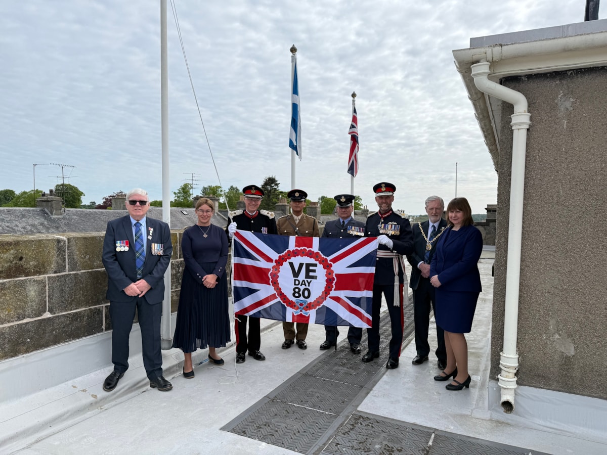 Moray Council civic and military group with VE Day 80 flag