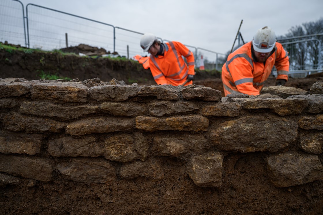 Archaeological excavation of a Roman trading settlement, Blackgrounds, South Northamptonshire-5: Archaeologists working behind a Roman wall at the archaeological excavation of a wealthy Roman trading settlement, known as Blackgrounds, in South Northamptonshire. 

Tags: Archaeology, Roman, Northamptonshire, Phase One, History, Heritage