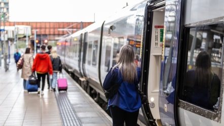 Image shows a family boarding a Northern train