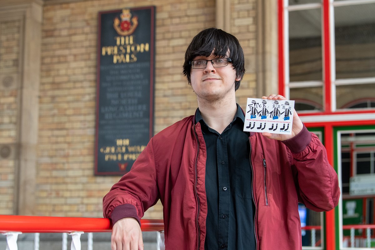 Jason, intern from DFN Project SEARCH, holding one of the six postcards designed to retell the story of the Dick, Kerr Ladies football team