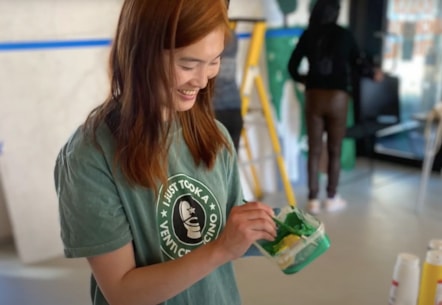 Woman painting Recovery Mural.