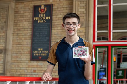Harry, intern from DFN Project SEARCH, holding one of the postcards created to raise awareness of the Dick, Kerr Ladies football team