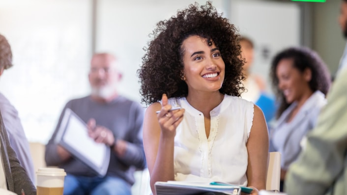 Woman smiling with folder and pen (image)