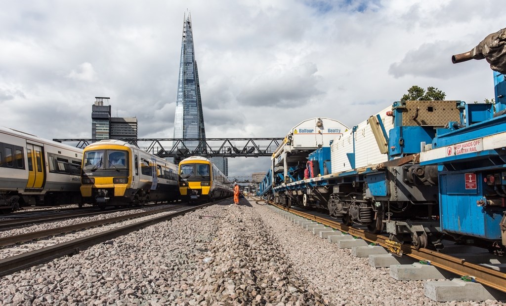 London Bridge - track laying in September 2017: Three Southeastern trains pass the Balfour Beatty track laying train in the shadow of the Shard outside London Bridge