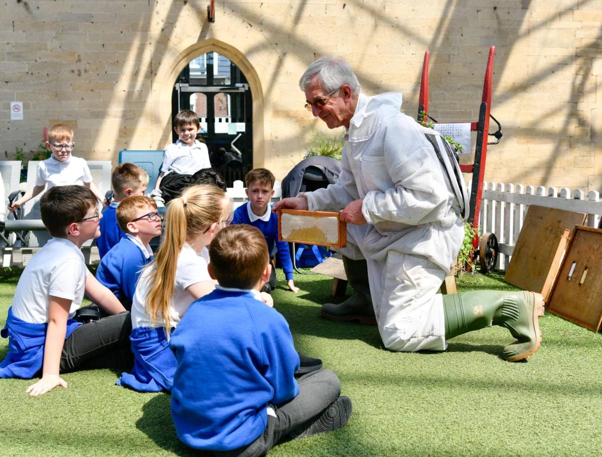 Beekeeper, Harold Bowron, gives pupils from Robert Ferguson Primary School an insight into a beehive for World Bee Day