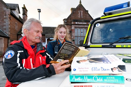 Left to right: Penrith Mountain Rescue volunteer, Stephen Crowsley, and Avanti West Coast Customer Service Assistant, Laura Hazelhurst, with books donated to Penrith station's charity bookshelf.