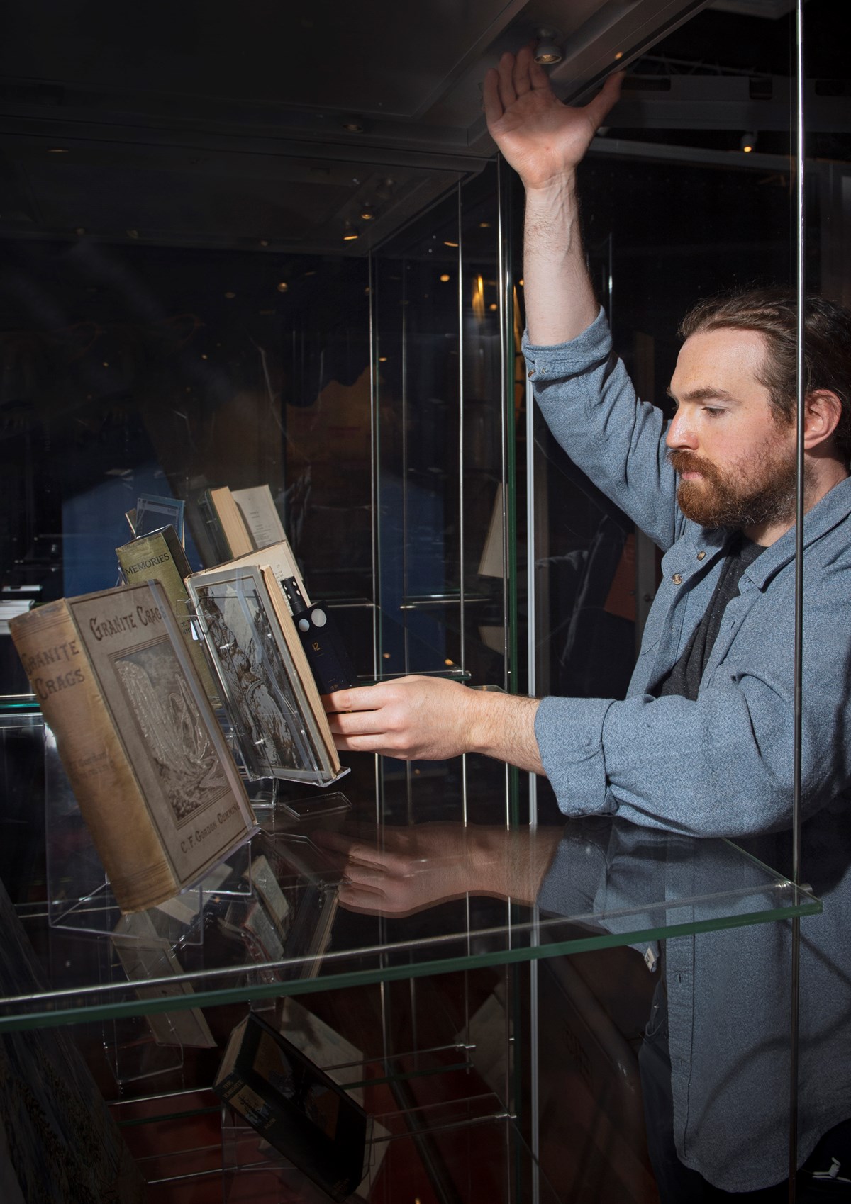 Library Conservator Ryan Gibson ensures the correct temperature in the exhibition case during the installation of Petticoats & Pinnacles