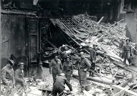 The People's Pantry, Friar Street, Reading, 1943, showing the bomb damage from 10 February. A number of men sift through the rubble.