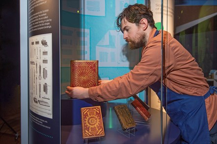 Conservation Exhibitions Specialist Ryan Gibson installing examples of Scottish bookbinding styles. Credit: Neil Hanna