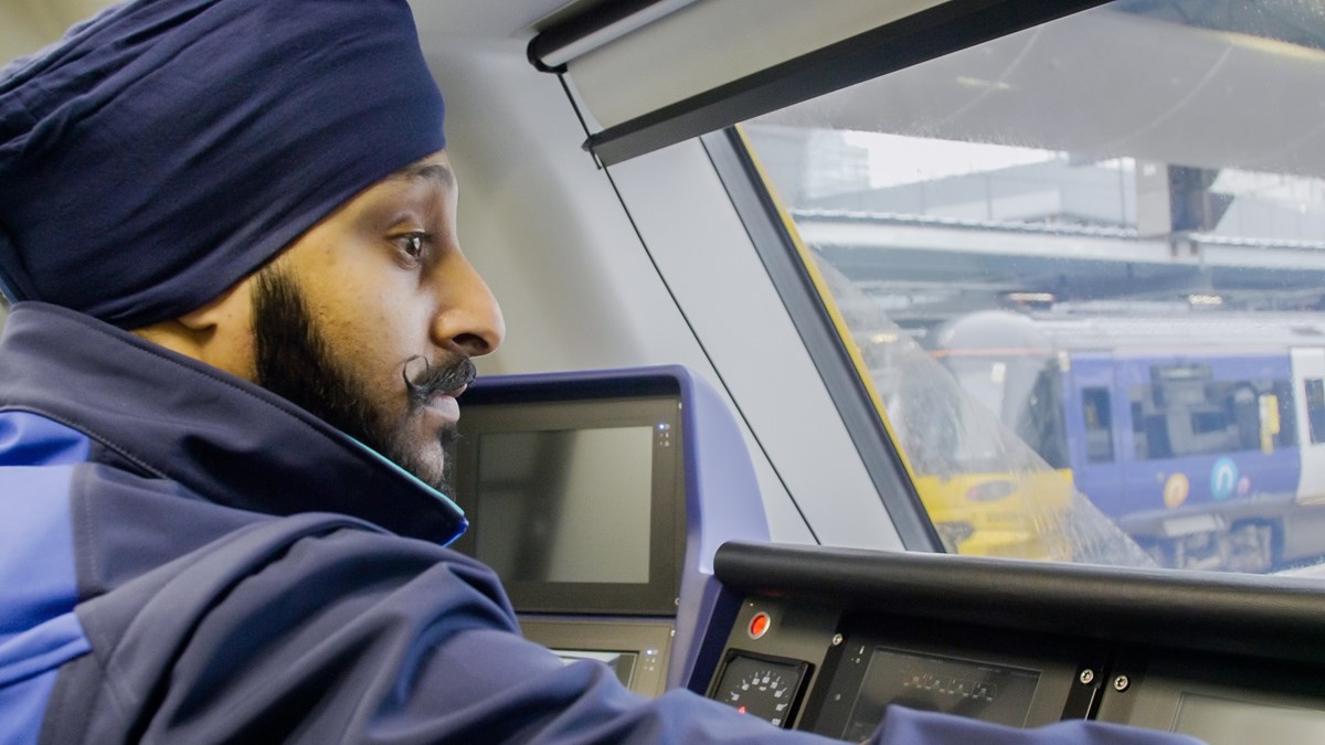 Images shows a Northern driver in the cab of a train