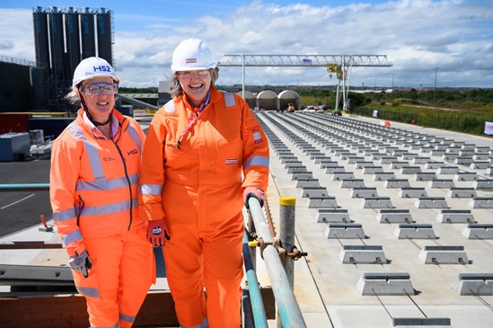 STRABAG factory in Hartlepool begins casting tunnel segments for HS2 London tunnels-10: Ruth Todd CBE, Chief Commerical Officer, HS2 & Jill Mortimer MP, Member of Parliament for Hartlepool, standing over rail head at the STRABAG factory in Hartlepool.