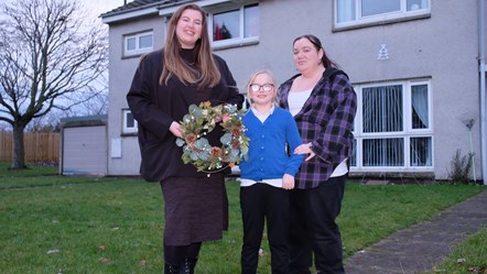 Cllr Amber Dunbar, Moray Council’s Housing and Safety Committee chair, presents new Pinegrove tenant Karen McLennan and her nine-year-old daughter Teigan-Leigh with a Christmas wreath.