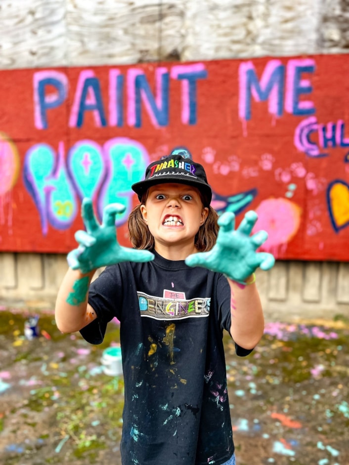 FestivalofPlay - Seagulls: Image shows a young child with paint on her hands, and a sign behind her saying 'paint me'.