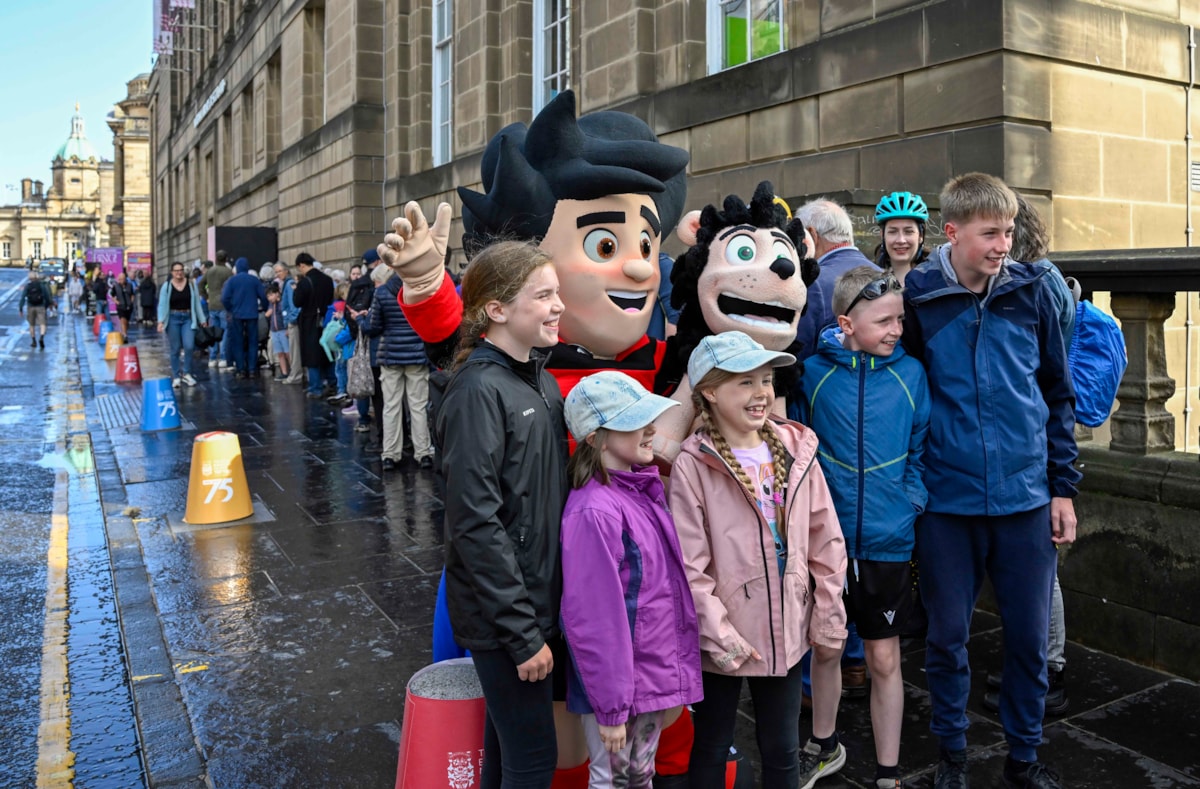 Beano fans have their photo taken with Dennis the Menace while they queue outside the National Library of Scotland's George IV Bridge building. The Library was giving away special centenary editions of the comic to mark the Library's 100 birthday, which fell on 7 August. Credit: Neil Hanna
