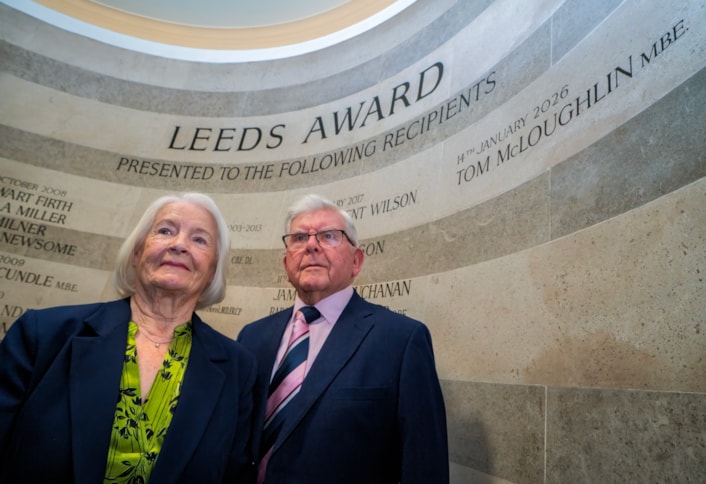 Tom McLoughlin-5: Tom McLoughlin with his wife Helen, standing in front of the Leeds Award winners' wall in Leeds Civic Hall.