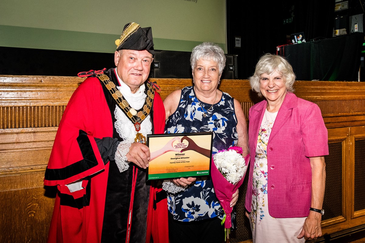 Carer Georgina Wheeler is presented with her 2023 award for Family Carer of the Year by the Mayor of Islington and Cllr Janet Burgess