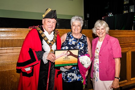 Carer Georgina Wheeler is presented with her 2023 award for Family Carer of the Year by the Mayor of Islington and Cllr Janet Burgess