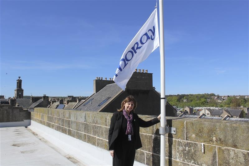 A photo of Moray Council Chief Executive Karen Greaves, beside a lowered Moray Council flag, for International Workers Memorial Day