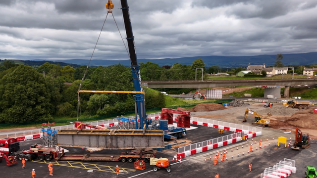 A still of a steel section being lifted onto tressels: A still of a steel section being lifted onto tressels