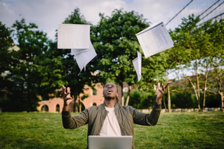 young black male student throwing papers in the air