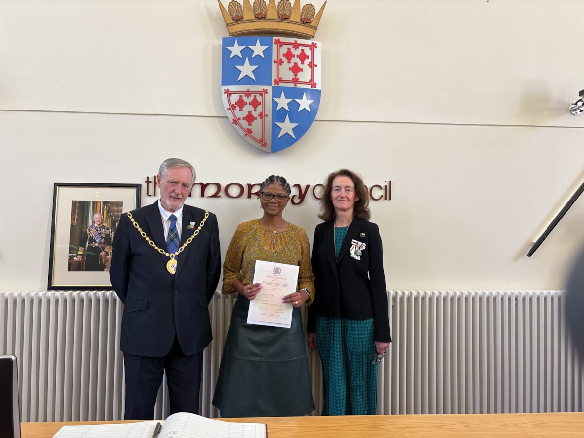 Salma Ralph (Centre) receiving her citizenship certificate from Moray Council Civic Leader Cllr John Cowe and Vice Lord-Lieutenant of Moray, Nancy Robson.