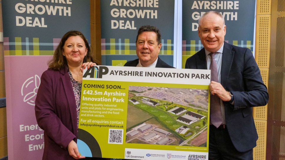 3 officials standing in front of Ayrshire Growth Deal banners, holding sign for new innovation park