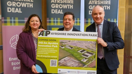 3 officials standing in front of Ayrshire Growth Deal banners, holding sign for new innovation park