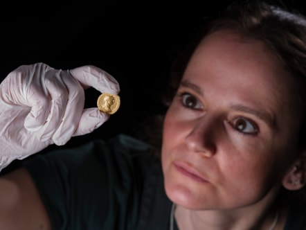 Conservator Bethan Bryan examines the gold Aureus of Trajan. Image © National Museums Scotland (2)