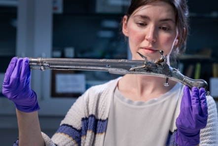 Curator Ella Paul examines the pistol at National Museums Scotland. Image © Duncan McGlynn (2)