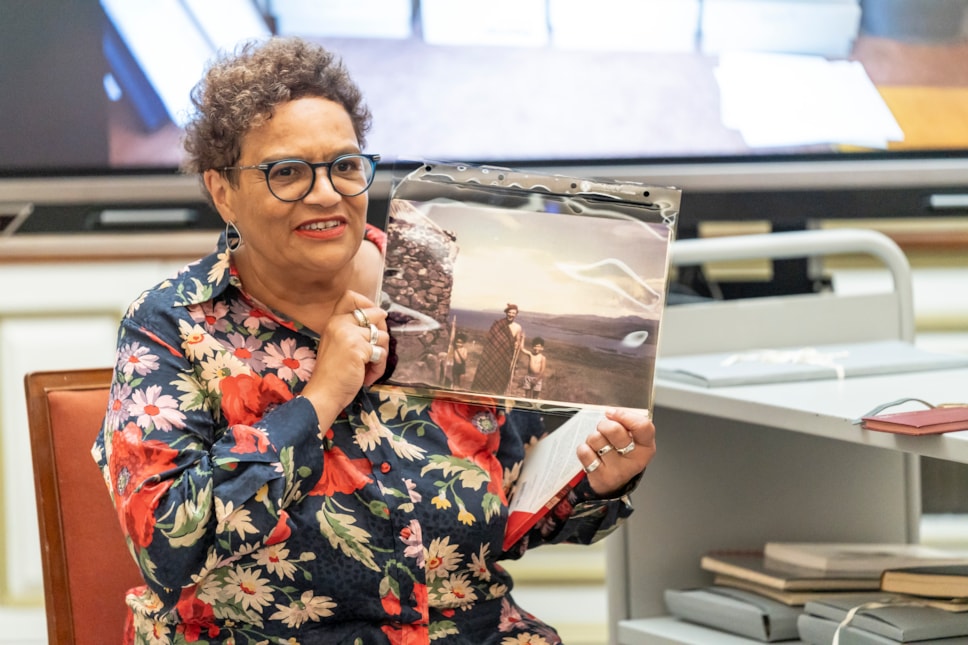 Jackie Kay holding up a family photo from her archive - Credit Aly Wight