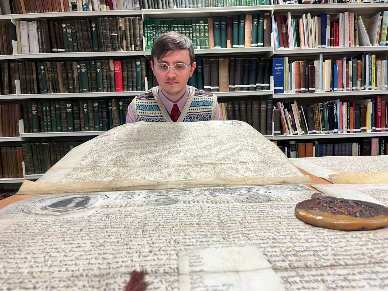 The Leeds Charter: Alex Pearson, archives assistant with West Yorkshire Archive Service with the copy of the Leeds Charter and  a second ornate charter, granted decades later in 1661 by Charles II.
The granting of the prestigious charter changed the course of the city’s history, laying the foundations of modern-day Leeds by incorporating it as a “free borough” and a “body corporate and politic.”