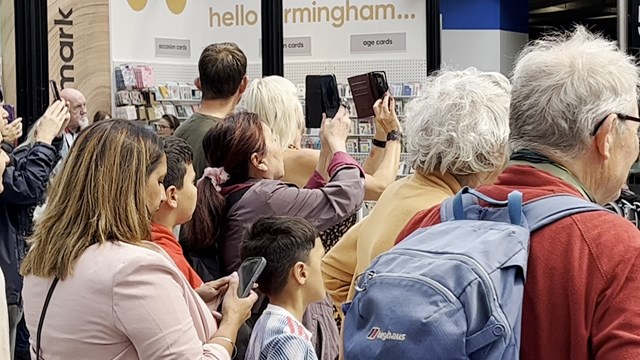 Crowds taking photos and enjoying Ozzy the bull at Birmingham New Street