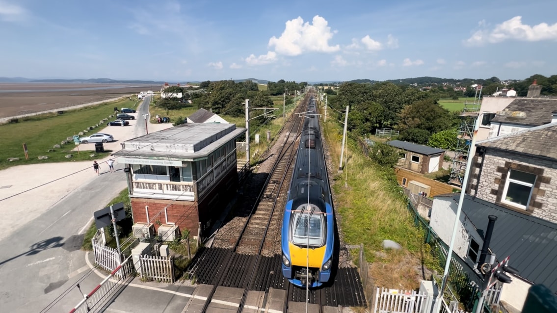 Lumo train passing beside Hest Bank signal box