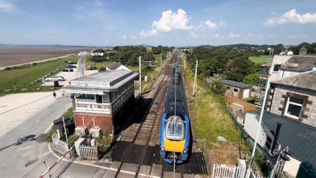 Lumo train passing beside Hest Bank signal box: Lumo train passing beside Hest Bank signal box
