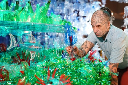 Artist George Nuku puts the finishing touches to the installation of the artwork Bottled Ocean 2123, an imagined underwater landscape made from recycled plastic. The work will go on show in the exhibition Rising Tide: Art and Environment in Oceania, which opens on August 12 at the National Museum of Scotland. Image credit: Stewart Attwood