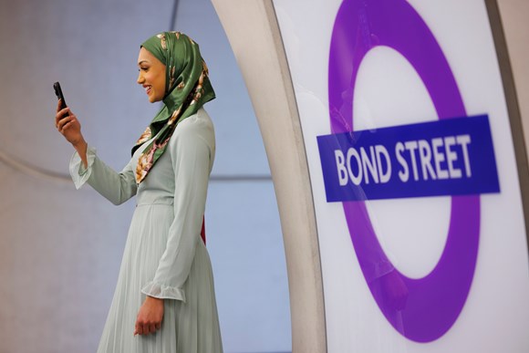 Mayor heralds first Elizabeth line stations to get high-speed mobile coverage: TfL Image -  Customer using phone at Bond Street Elizabeth line station