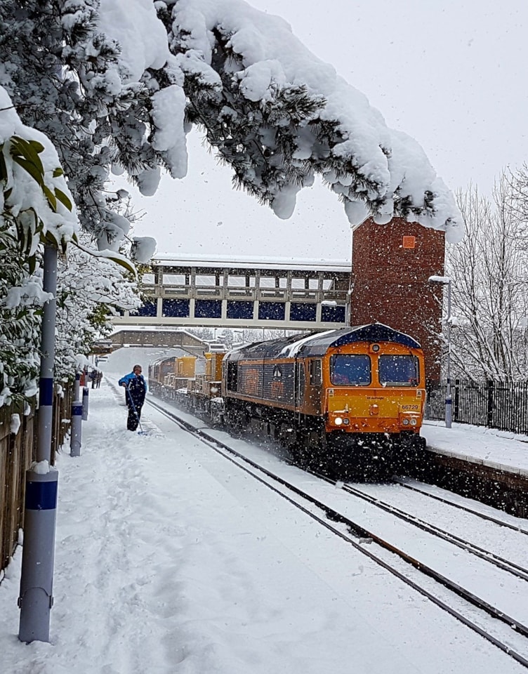 A freight train at a snowy station