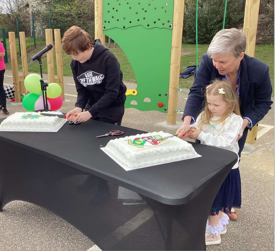 Keith Primary's Head Teacher, Susan Buchan cutting a celeberation cake with pupils during the playground opening event.