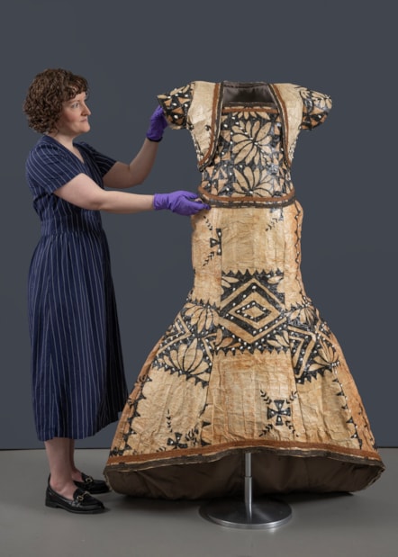 Curator Ali Clark prepares the barkcloth wedding dress for display. Photo © Neil Hanna (4)