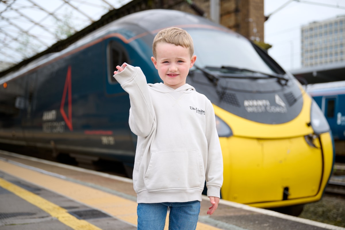 Daniel Rogerson stands in front of his favourite train - an Avanti West Coast Pendolino - which he enjoys watching travel along the West Coast Main Line near his home in Wigan.