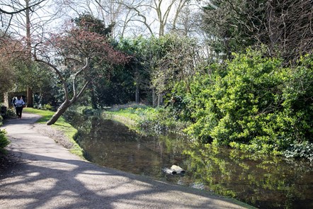A jogger runs down the New River Walk on a sunny day