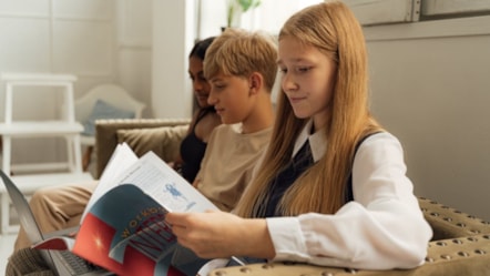 Teenagers reading on sofa cropped