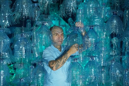 Artist George Nuku puts the finishing touches to the installation of the artwork Bottled Ocean 2123, an imagined underwater landscape made from recycled plastic. The work will go on show in the exhibition Rising Tide: Art and Environment in Oceania, which opens on August 12 at the National Museum of Scotland. Image credit: Stewart Attwood
