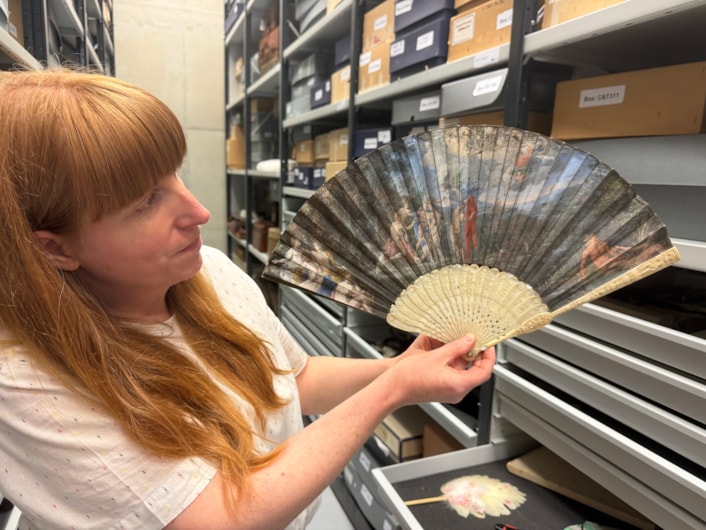Antique fans: Curator Natalie Raw holds a stunning 350-year-old fan depicting a legendary scene from the Trojan War which is being conserved at Leeds Discovery Centre.
Crafted in around the 1680s, the beautiful folding hand fan, complete with sticks carved from antique ivory, captures The Judgement of Paris, a fateful mythical moment which saw the Trojan prince choose which of three ancient goddesses- Hera, Athena, or Aphrodite- was the most beautiful.