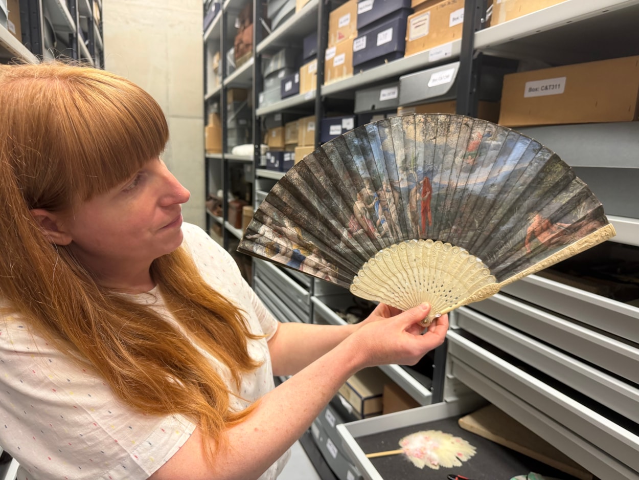 Antique fans: Curator Natalie Raw holds a stunning 350-year-old fan depicting a legendary scene from the Trojan War which is being conserved at Leeds Discovery Centre.
Crafted in around the 1680s, the beautiful folding hand fan, complete with sticks carved from antique ivory, captures The Judgement of Paris, a fateful mythical moment which saw the Trojan prince choose which of three ancient goddesses- Hera, Athena, or Aphrodite- was the most beautiful.