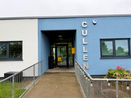 The newly improved entrance to Cullen Primary School, with a fresh blue and white exterior, new signage and a ramp providing access to the building.
